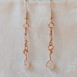 Handmade blush moonlight earrings with white Czech cut beads and pink seed beads wrapped in copper wire on rose-gold hooks.