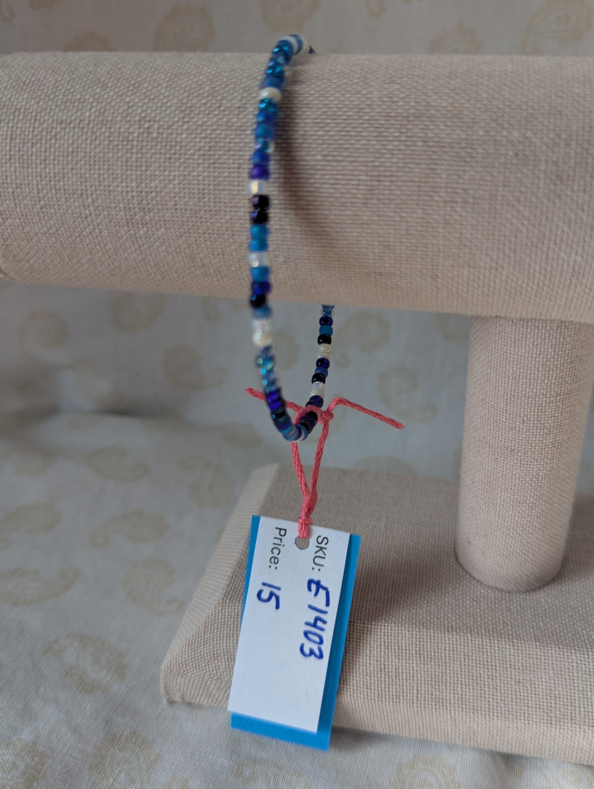 Handmade blue and white bracelet with mixed blue glass beads, white accent beads, and a silver lobster clasp.