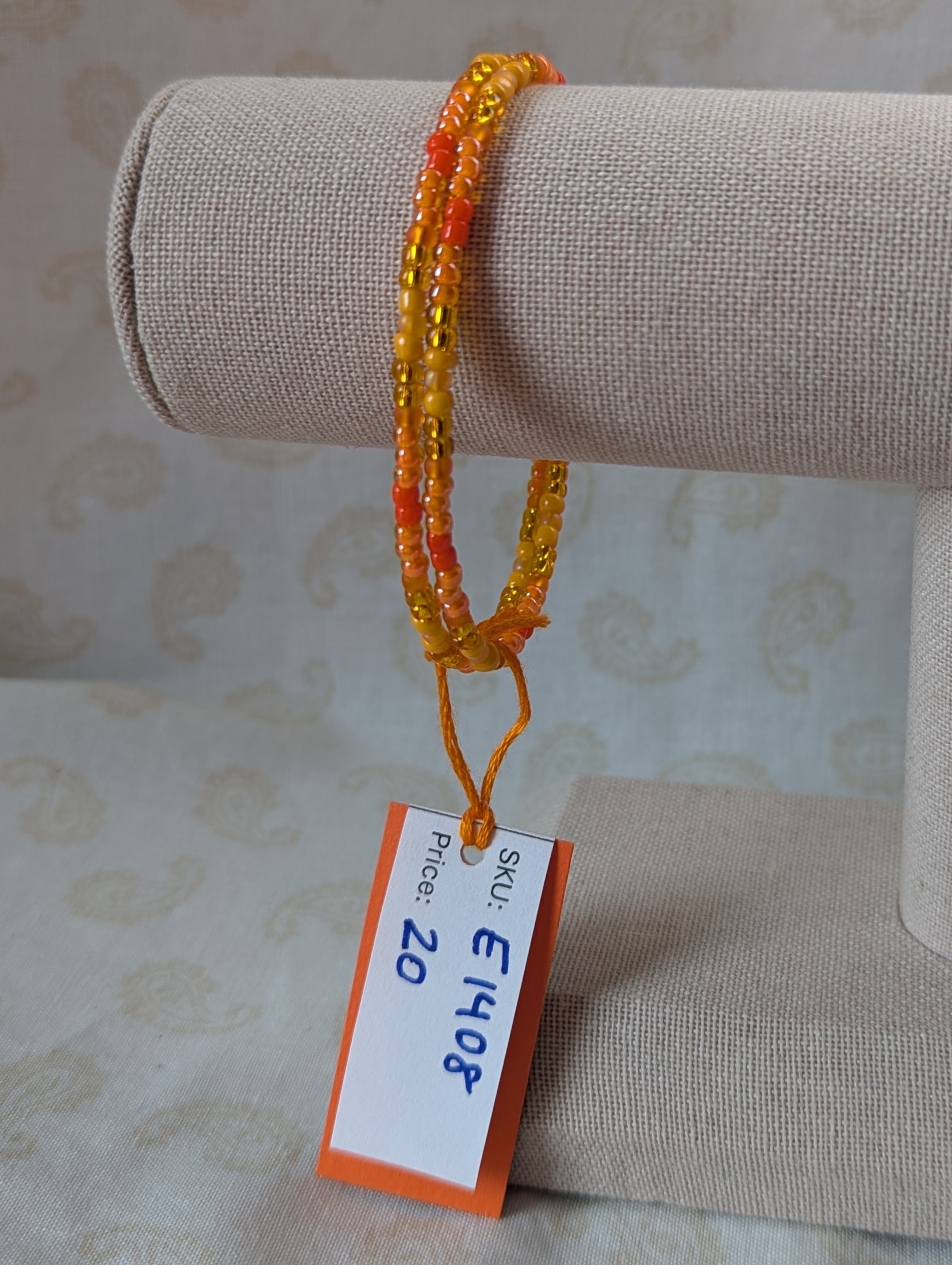 Orange memory wire bracelet with multiple shades and textures of orange glass beads, stretchy design with no clasp.