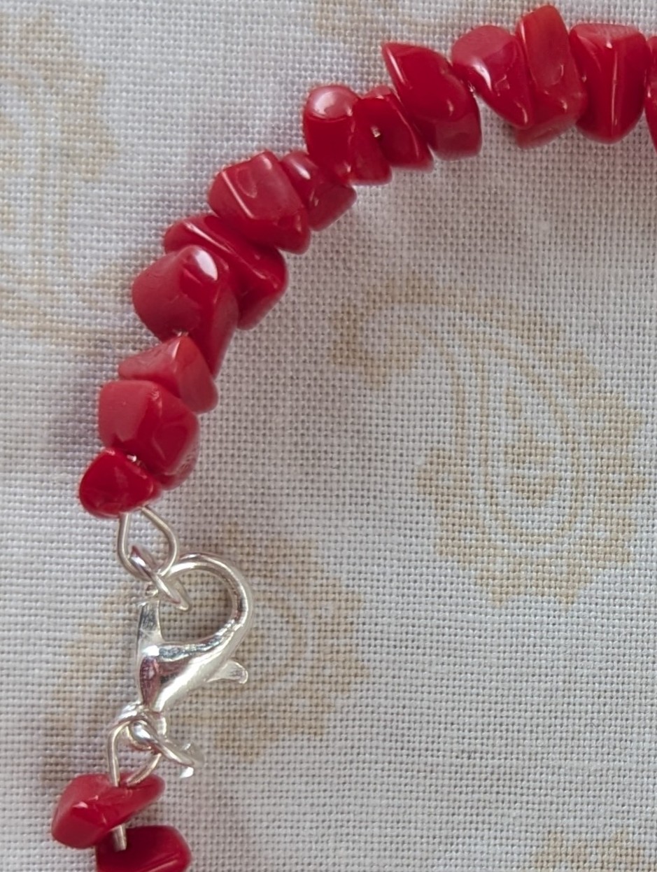 Red stone memory wire bracelet with polished cherry red chip stone beads and a silver-colored lobster clasp closure.