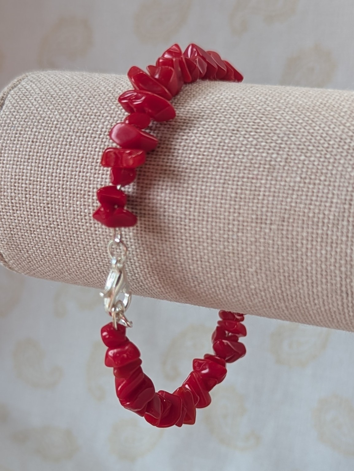 Red stone memory wire bracelet with polished cherry red chip stone beads and a silver-colored lobster clasp closure.