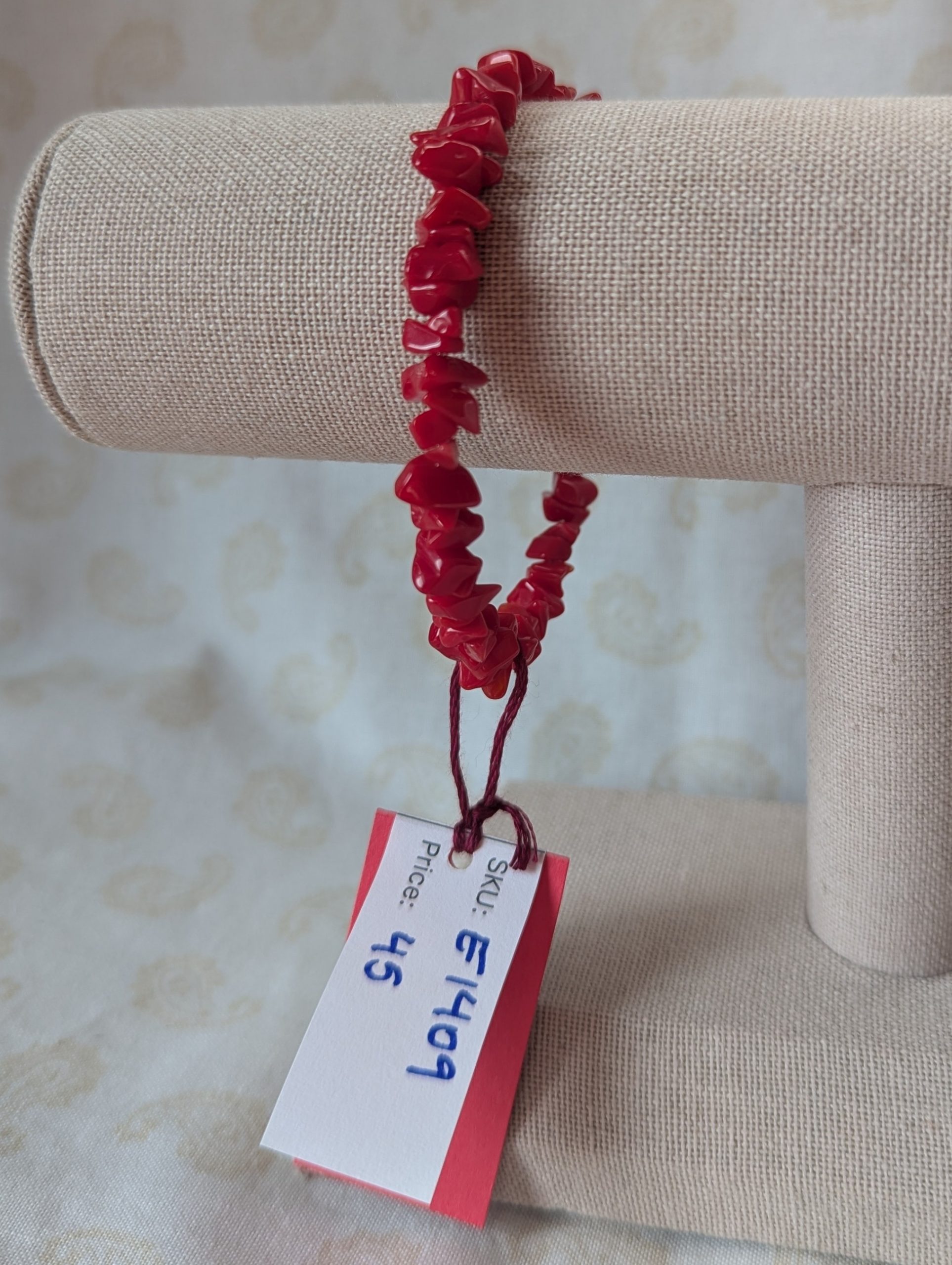 Red stone memory wire bracelet with polished cherry red chip stone beads and a silver-colored lobster clasp closure.