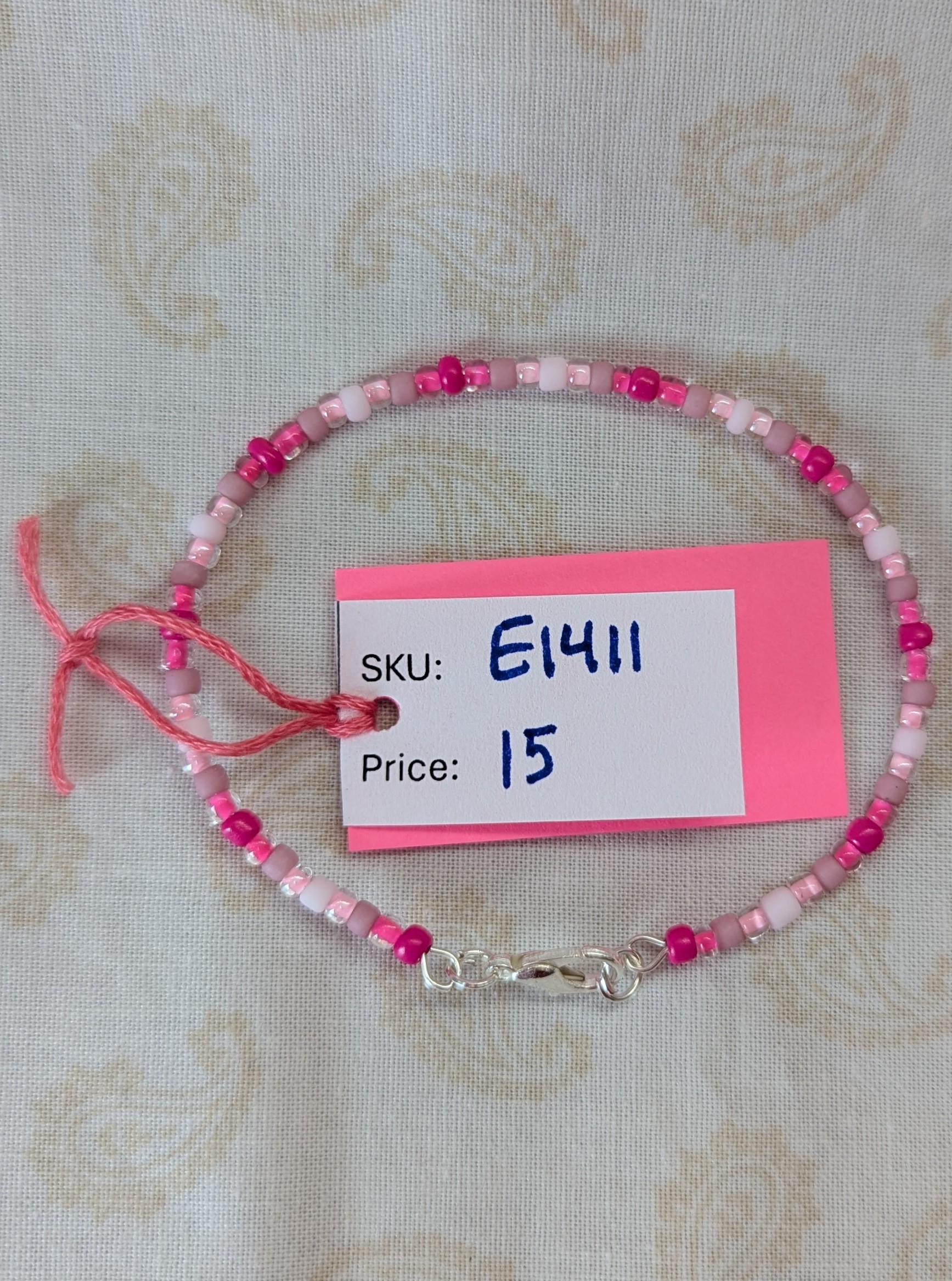 Pink memory wire bracelet with mixed pink beads in various textures and hues, finished with a silver-colored lobster clasp.