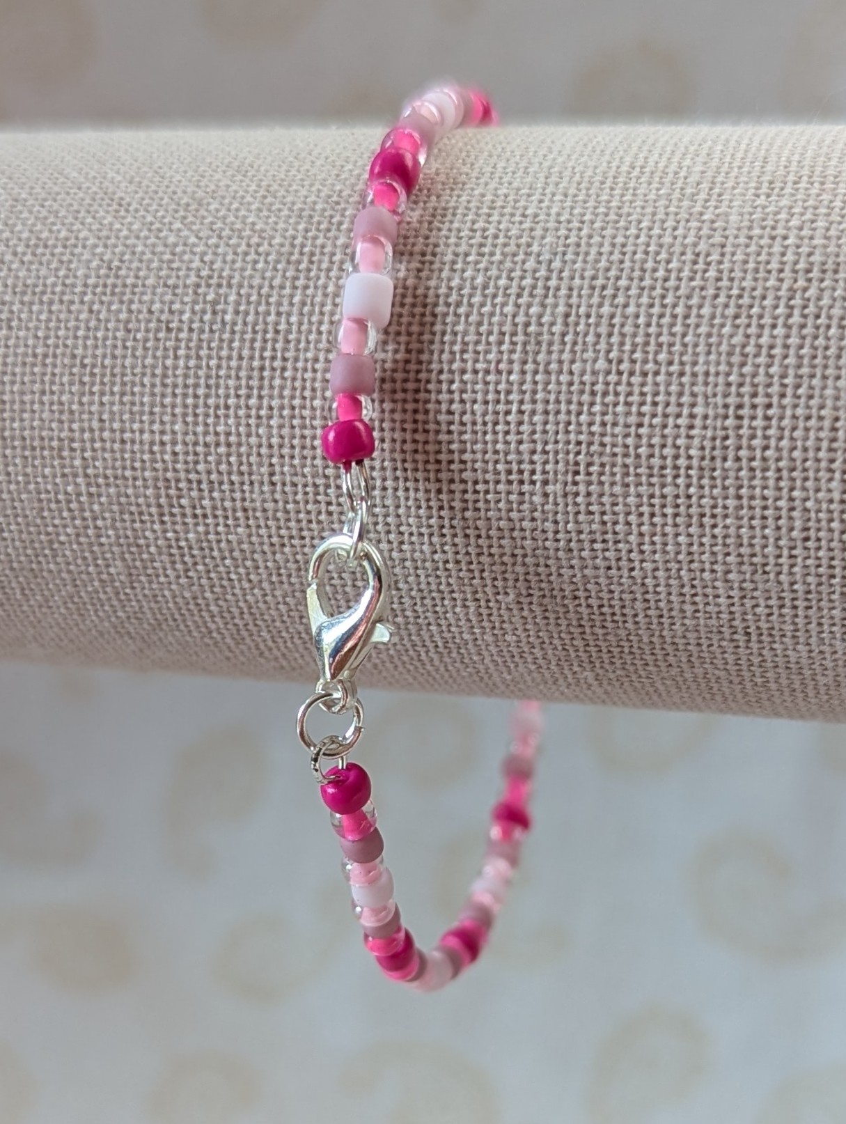 Pink memory wire bracelet with mixed pink beads in various textures and hues, finished with a silver-colored lobster clasp.