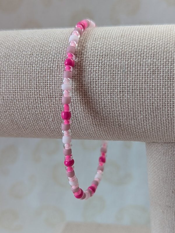 Pink memory wire bracelet with mixed pink beads in various textures and hues, finished with a silver-colored lobster clasp.
