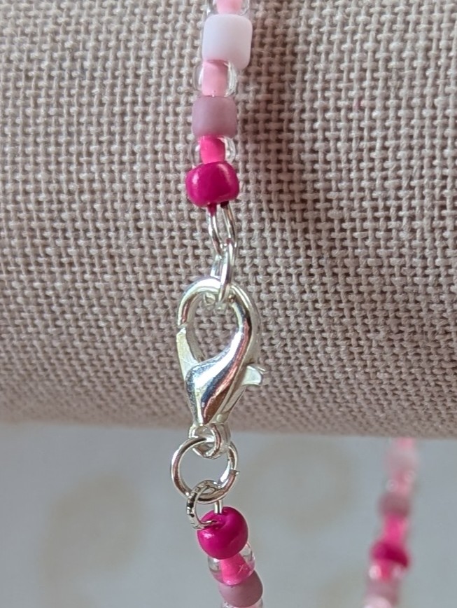 Pink memory wire bracelet with mixed pink beads in various textures and hues, finished with a silver-colored lobster clasp.