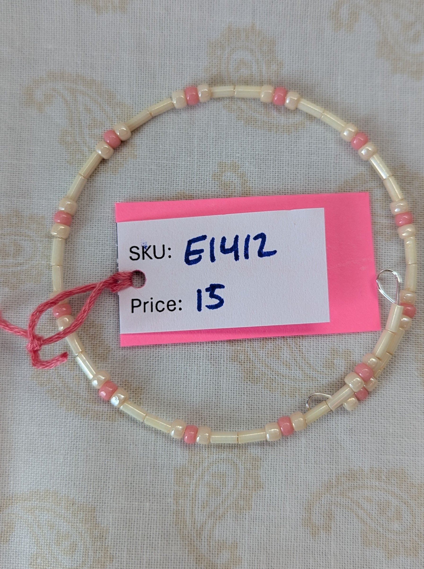 Cream and pink beaded bracelet with memory wire featuring ivory tube beads, cream round beads, and ballet pink accents with stretch overlap closure