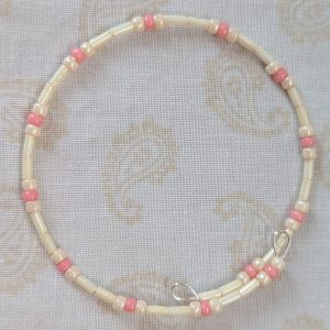 Cream and pink beaded bracelet with memory wire featuring ivory tube beads, cream round beads, and ballet pink accents with stretch overlap closure