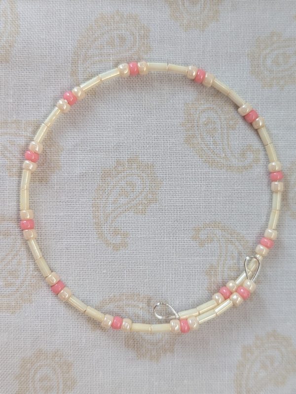 Cream and pink beaded bracelet with memory wire featuring ivory tube beads, cream round beads, and ballet pink accents with stretch overlap closure