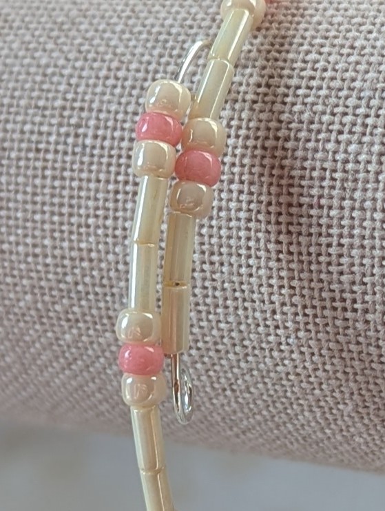 Cream and pink beaded bracelet with memory wire featuring ivory tube beads, cream round beads, and ballet pink accents with stretch overlap closure