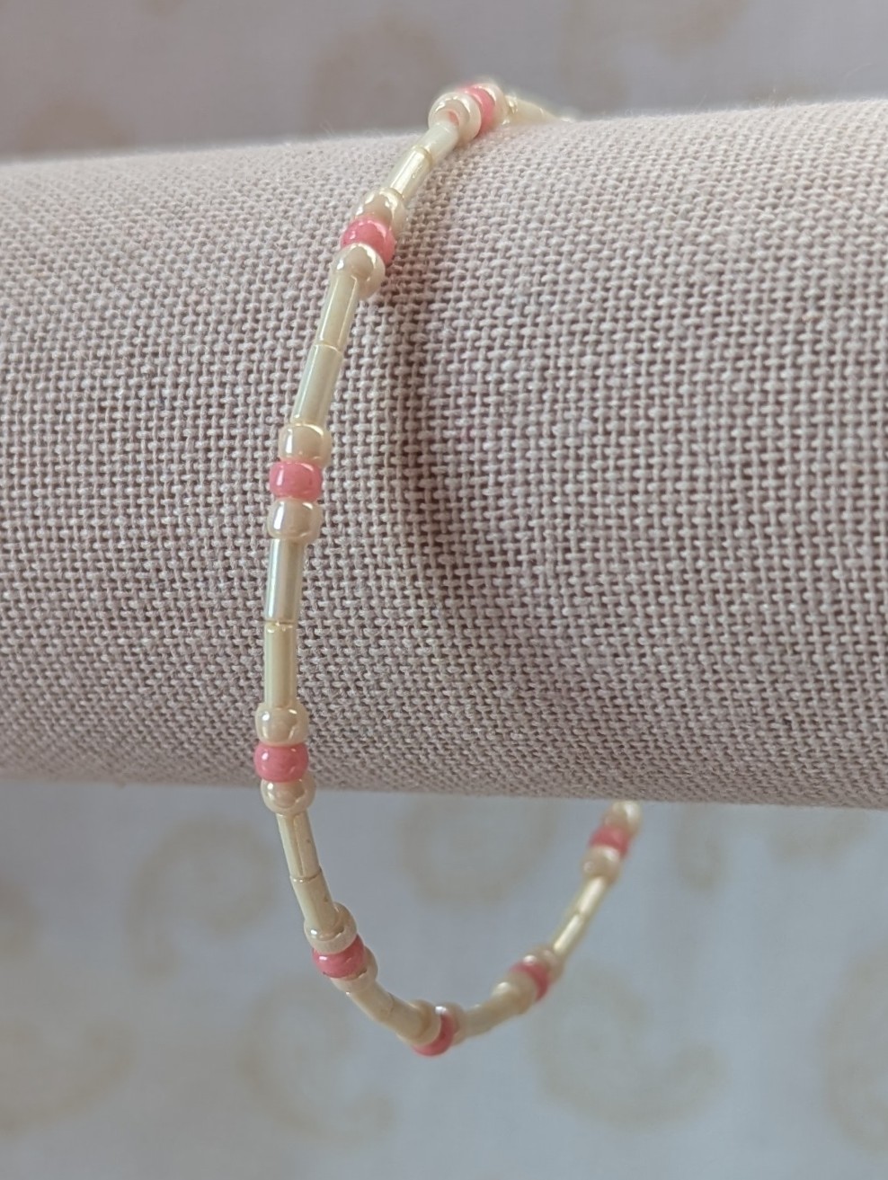 Cream and pink beaded bracelet with memory wire featuring ivory tube beads, cream round beads, and ballet pink accents with stretch overlap closure