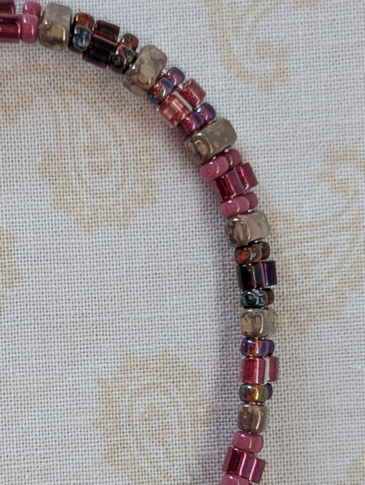 Double-strand memory wire bracelet with rose mauve, garnet, and taupe rectangular stone beads, finished with a silver lobster clasp.