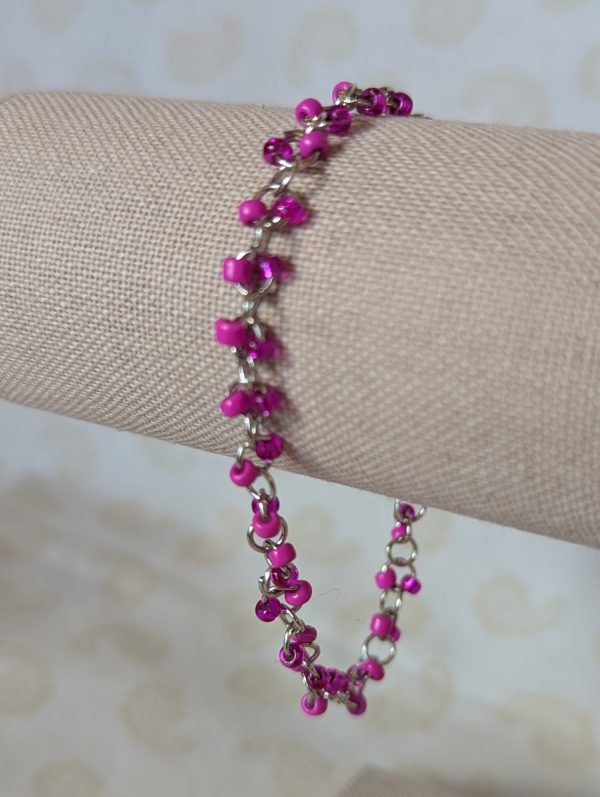 Steel-colored chain bracelet with alternating hot pink and silver-lined translucent pink glass beads and a lobster clasp.