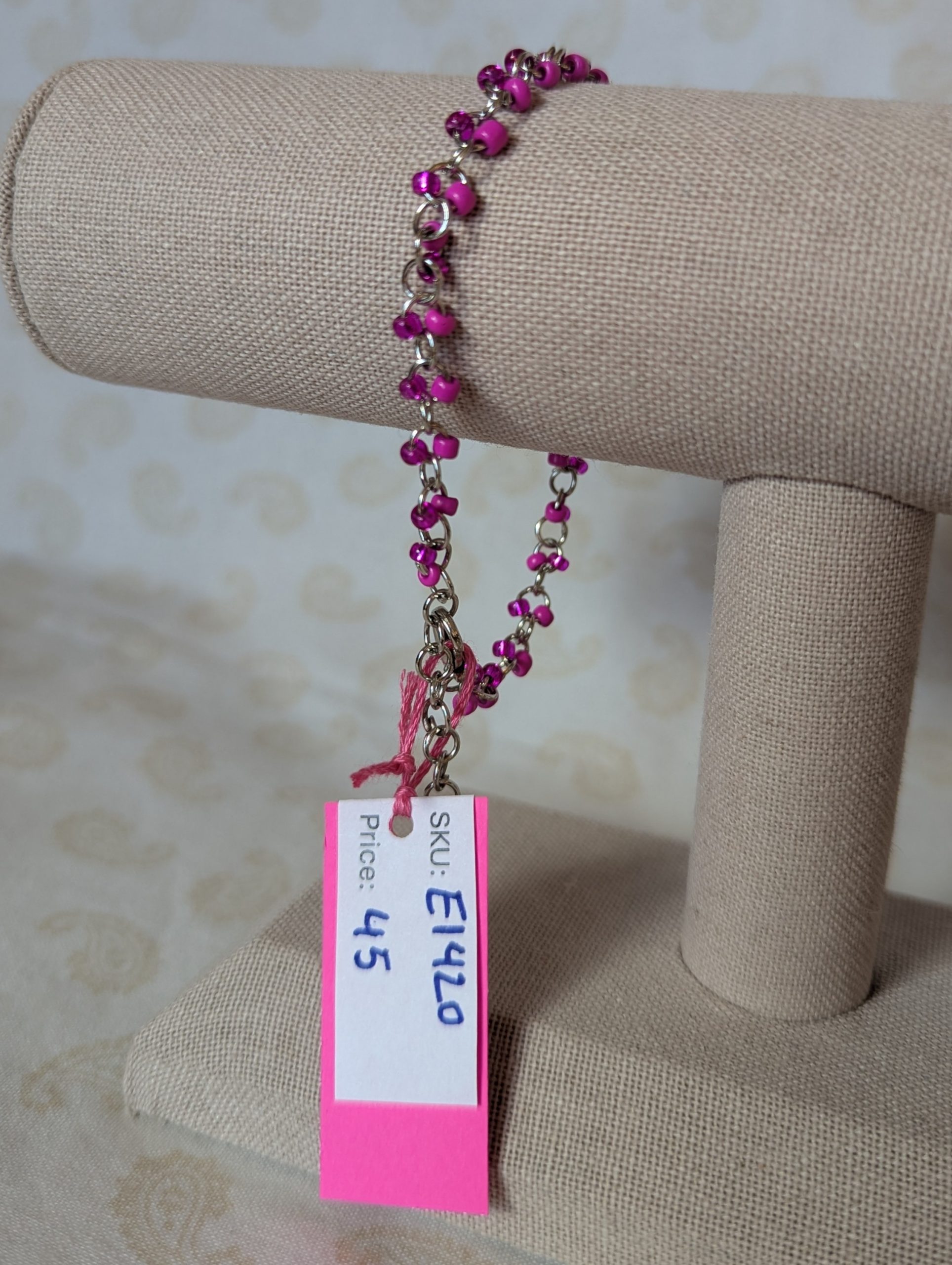 Steel-colored chain bracelet with alternating hot pink and silver-lined translucent pink glass beads and a lobster clasp.