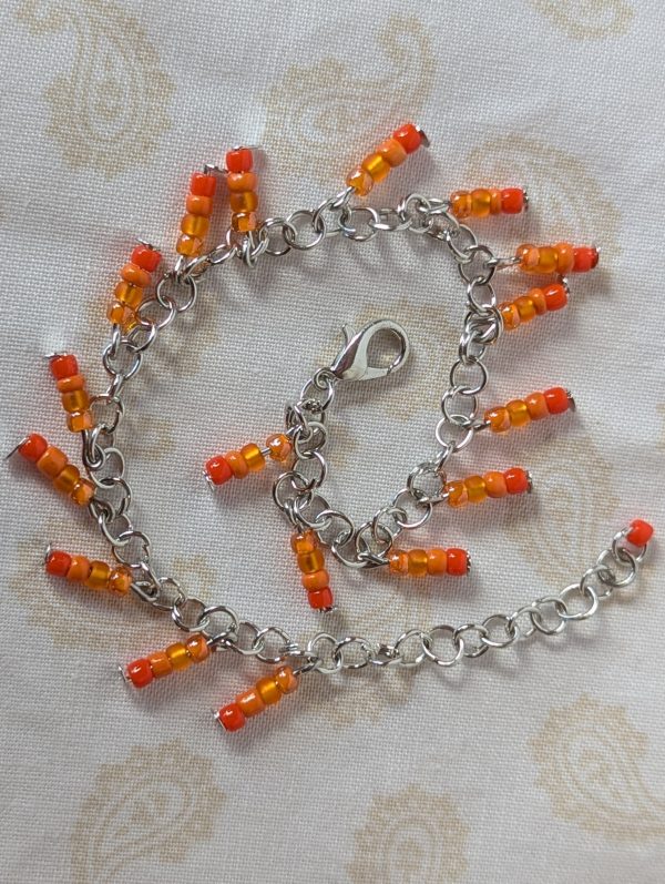 Steel-colored chain bracelet with dangling orange gradient bead clusters, featuring amber to burnt orange glass beads and a lobster clasp.