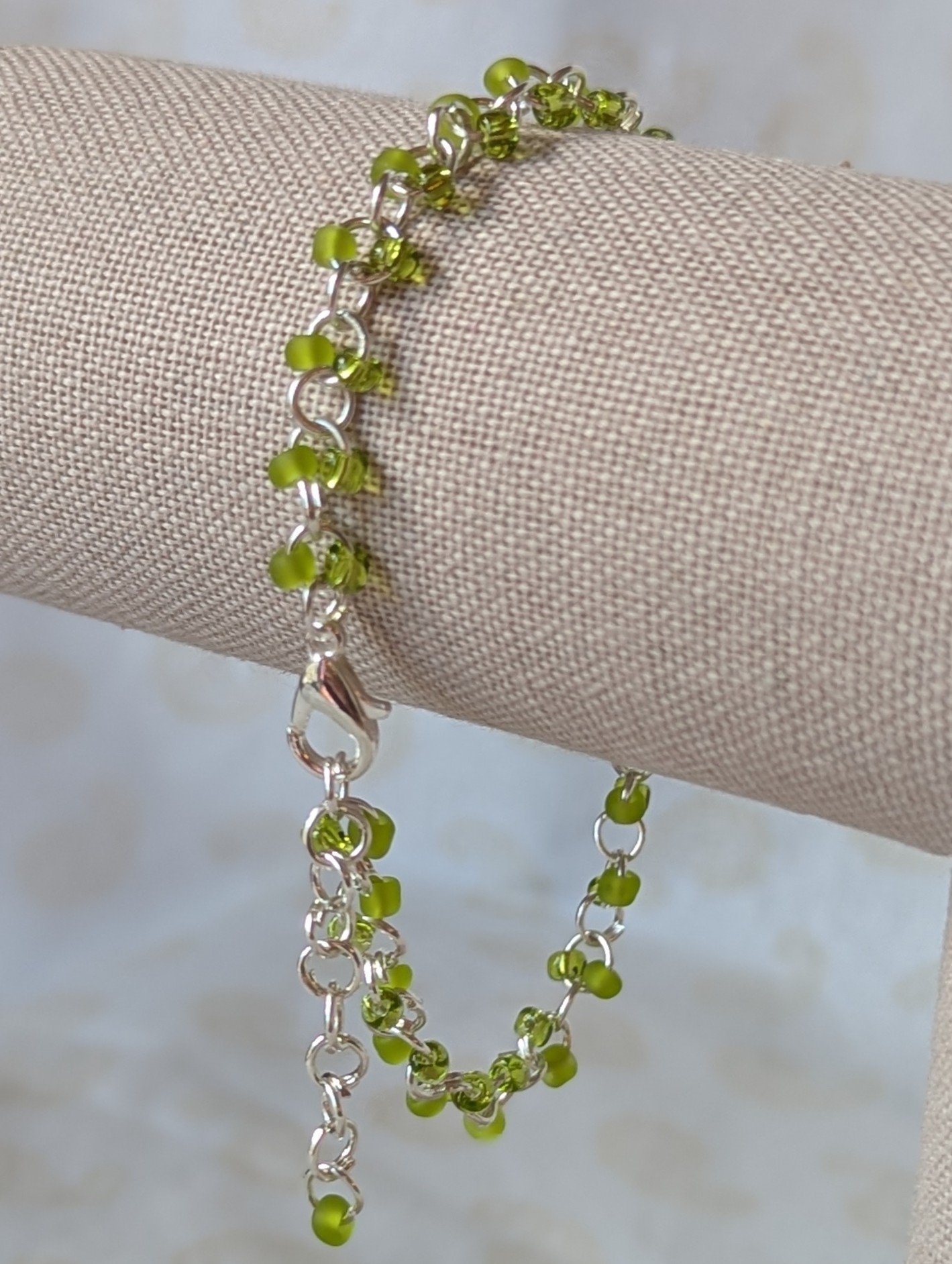 Silver-colored, hand-linked chain bracelet with paired green seed beads, featuring matte lime green and silver-lined lettuce green glass beads and a lobster clasp.