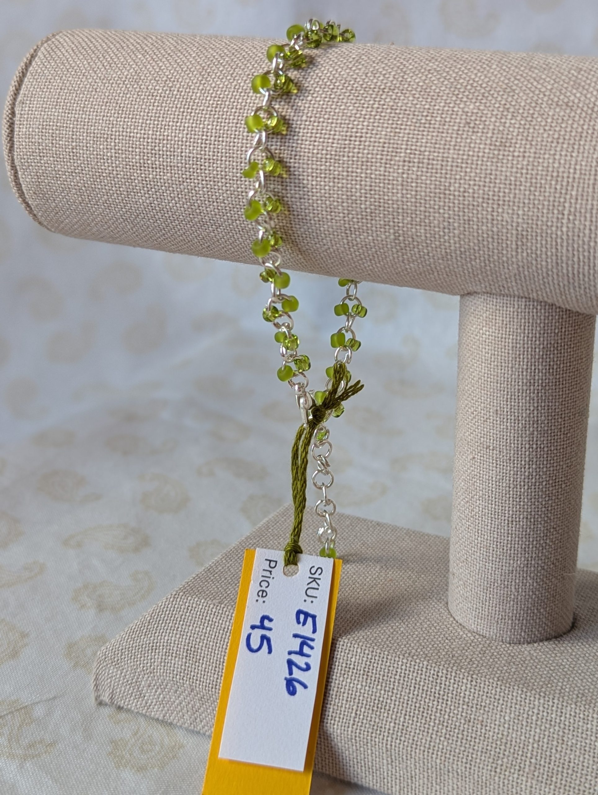Silver-colored, hand-linked chain bracelet with paired green seed beads, featuring matte lime green and silver-lined lettuce green glass beads and a lobster clasp.