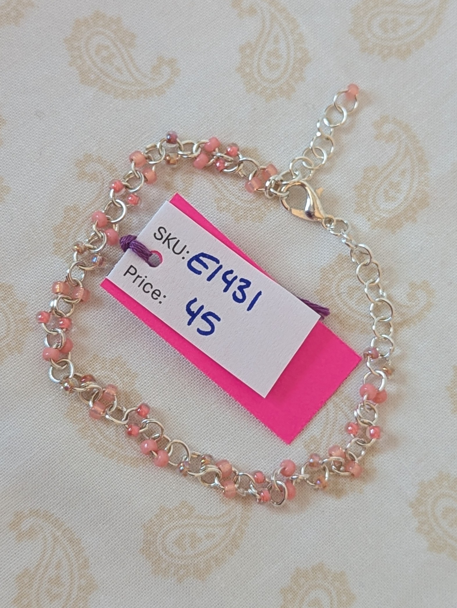 Blush and Petal Pink Beaded Chain Bracelet: a silver chain bracelet with pale pink seed beads in solid blush, pink-lined clear, and pearly iridescent finishes, secured with a lobster clasp.