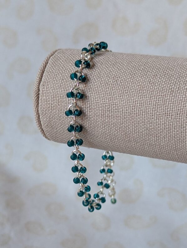 Hand-linked silver chain bracelet with paired teal seed beads, featuring matte teal and silver-lined teal glass beads and a silver lobster clasp.