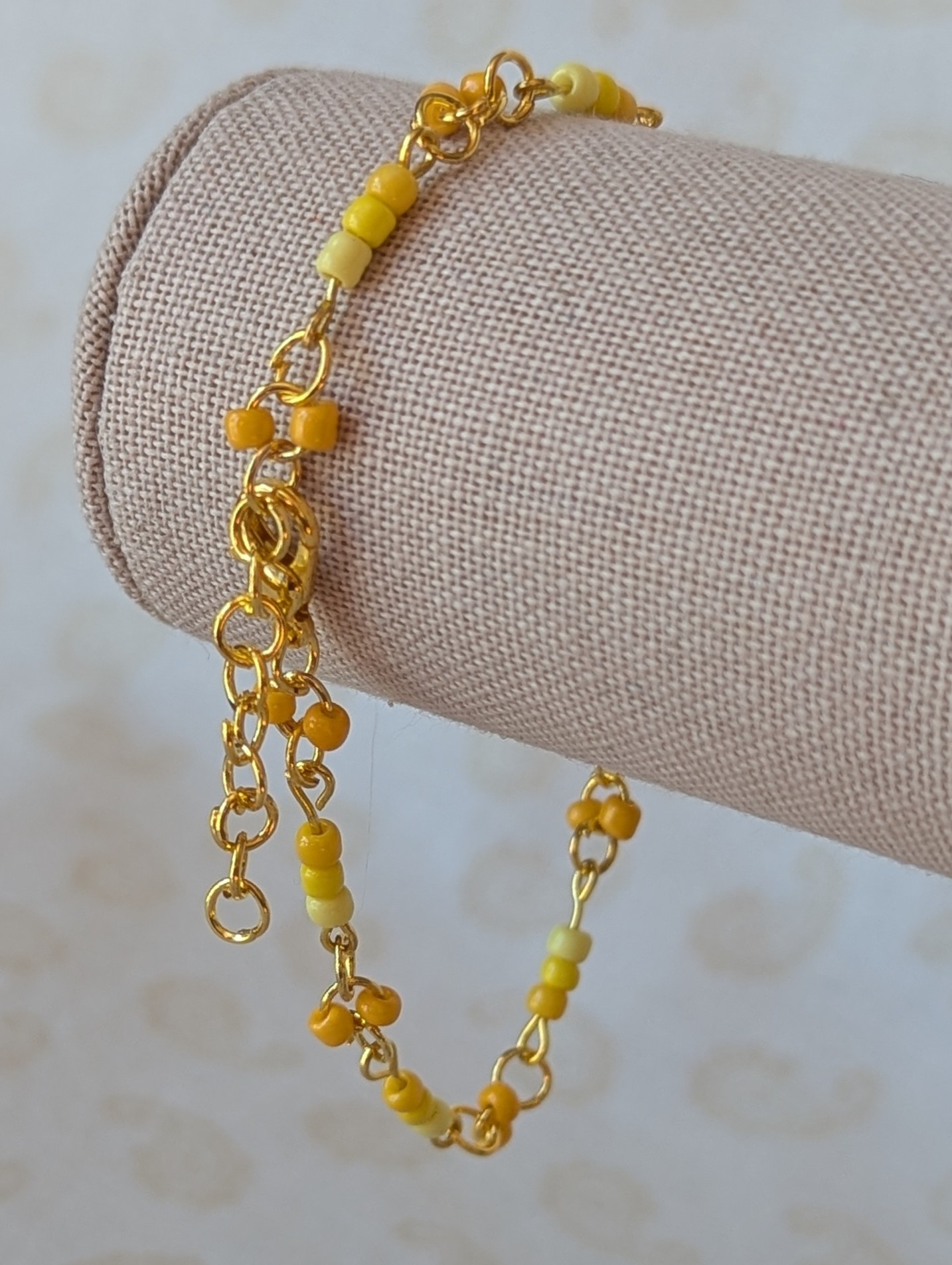 Handmade sunny yellow seed bead bracelet with gold chain links and lemon to marigold glass bead accents.
