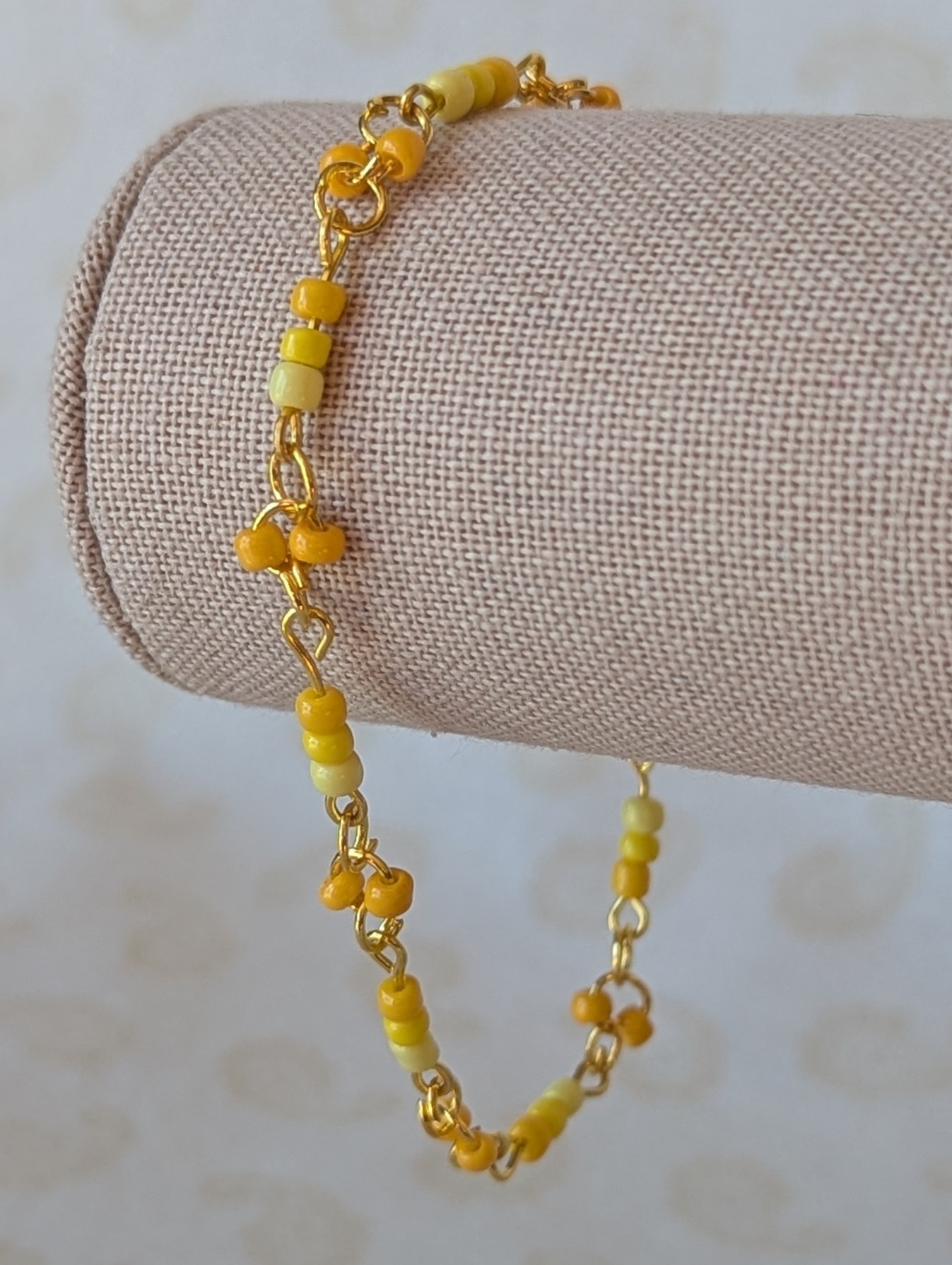 Handmade sunny yellow seed bead bracelet with gold chain links and lemon to marigold glass bead accents.