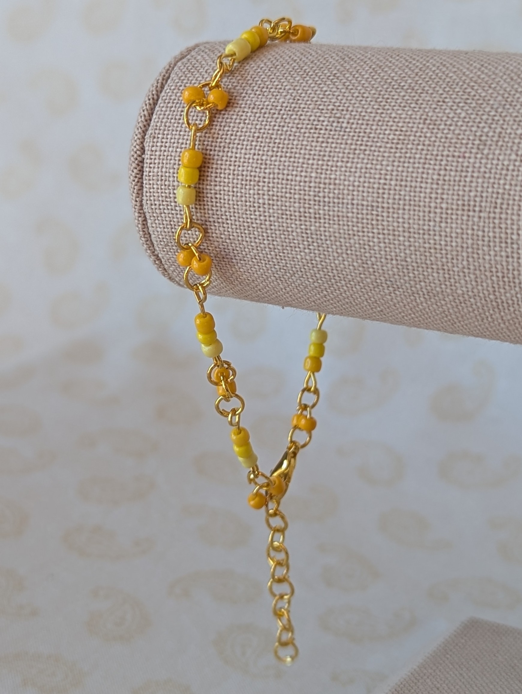 Handmade sunny yellow seed bead bracelet with gold chain links and lemon to marigold glass bead accents.