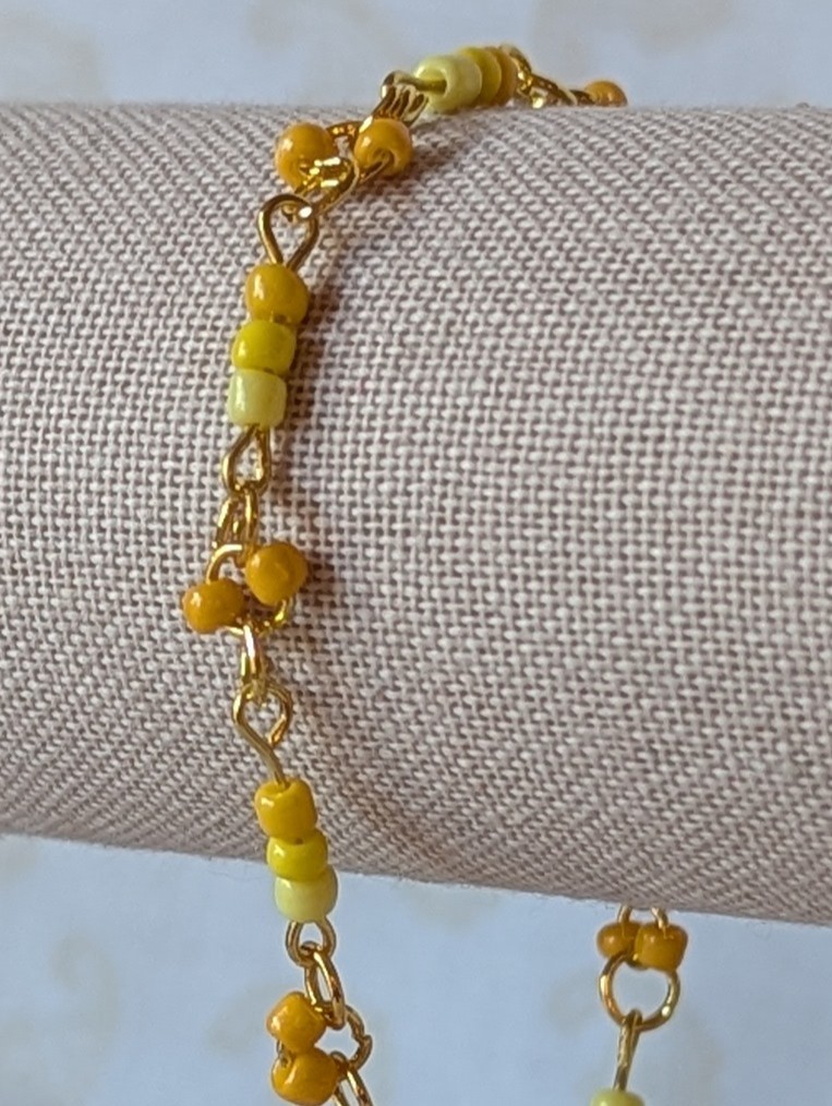 Handmade sunny yellow seed bead bracelet with gold chain links and lemon to marigold glass bead accents.