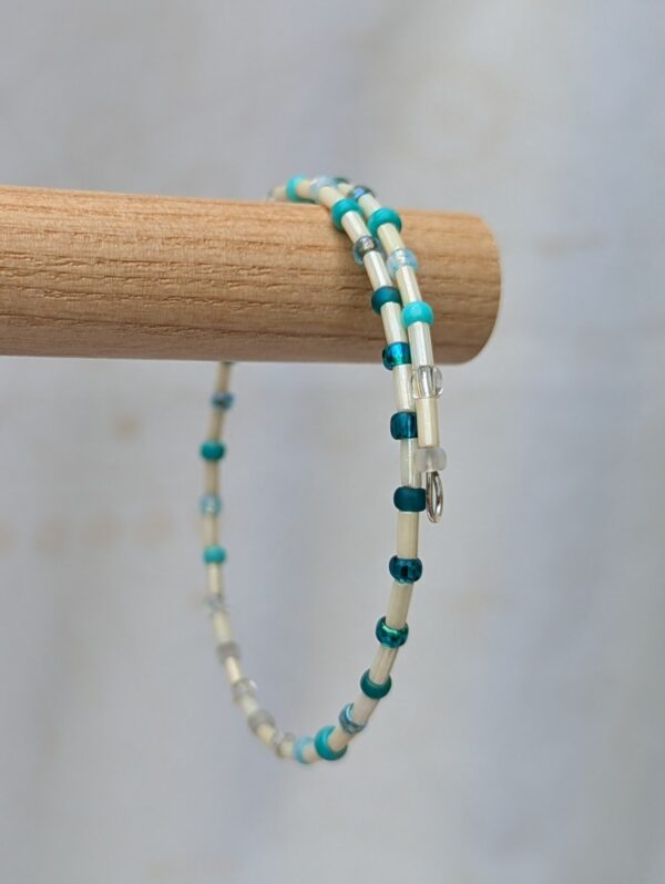 Handmade teal wrap bracelet with ivory tube beads, aqua and turquoise seed beads, and silver-colored memory wire.