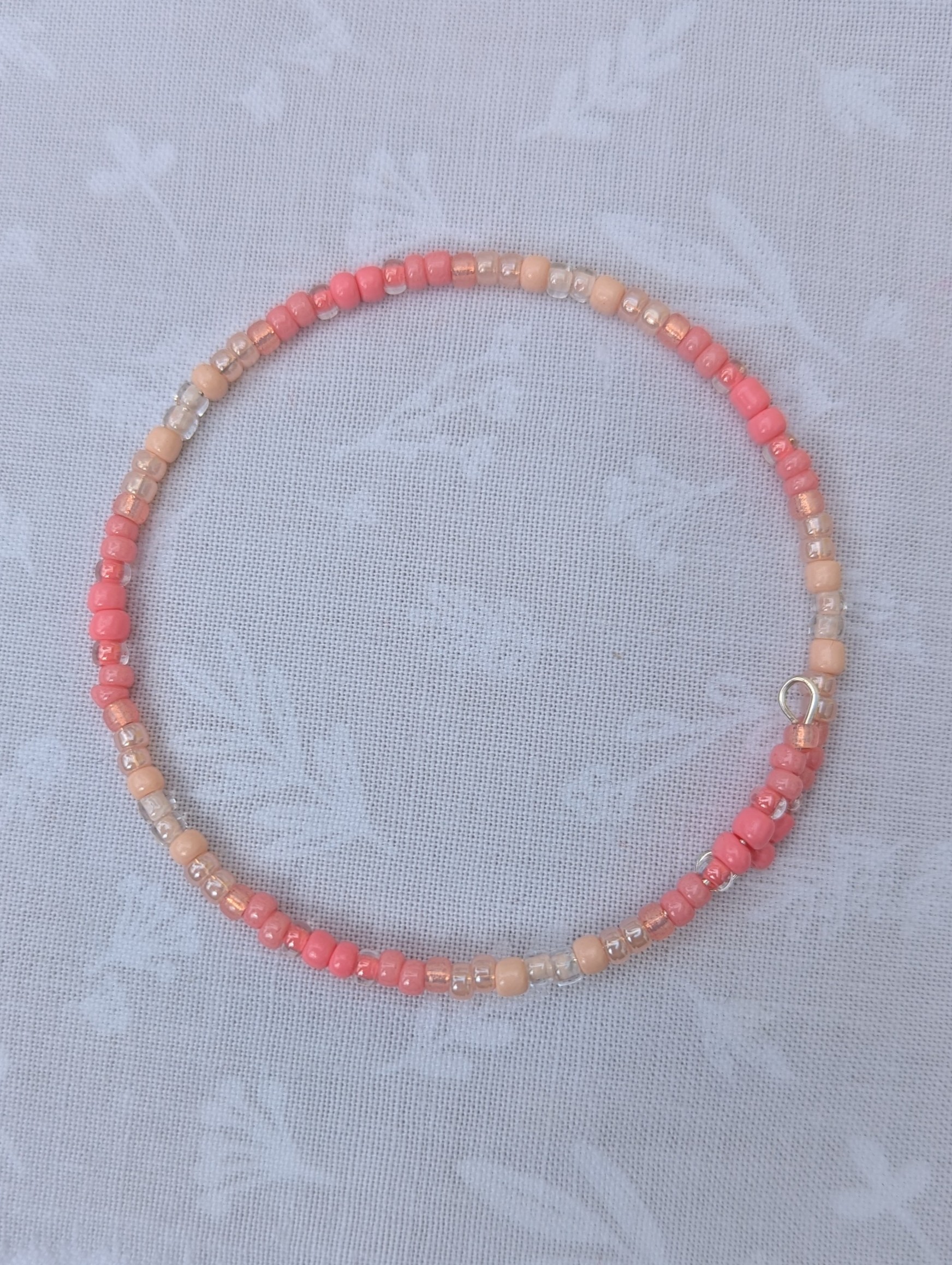 pink gradient bracelet with rose-gold memory wire and pale blush glass seed beads in mixed textures
