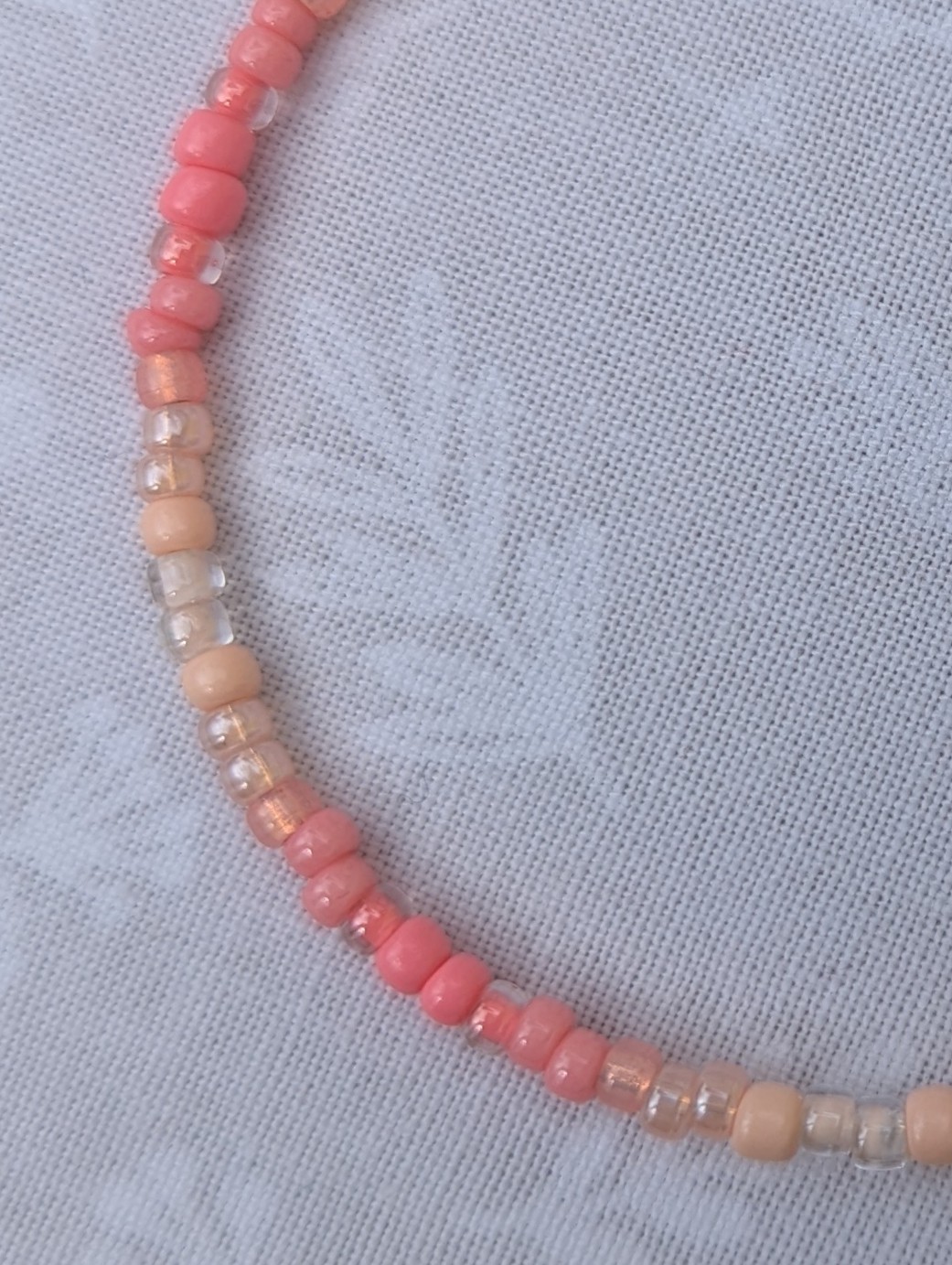 pink gradient bracelet with rose-gold memory wire and pale blush glass seed beads in mixed textures