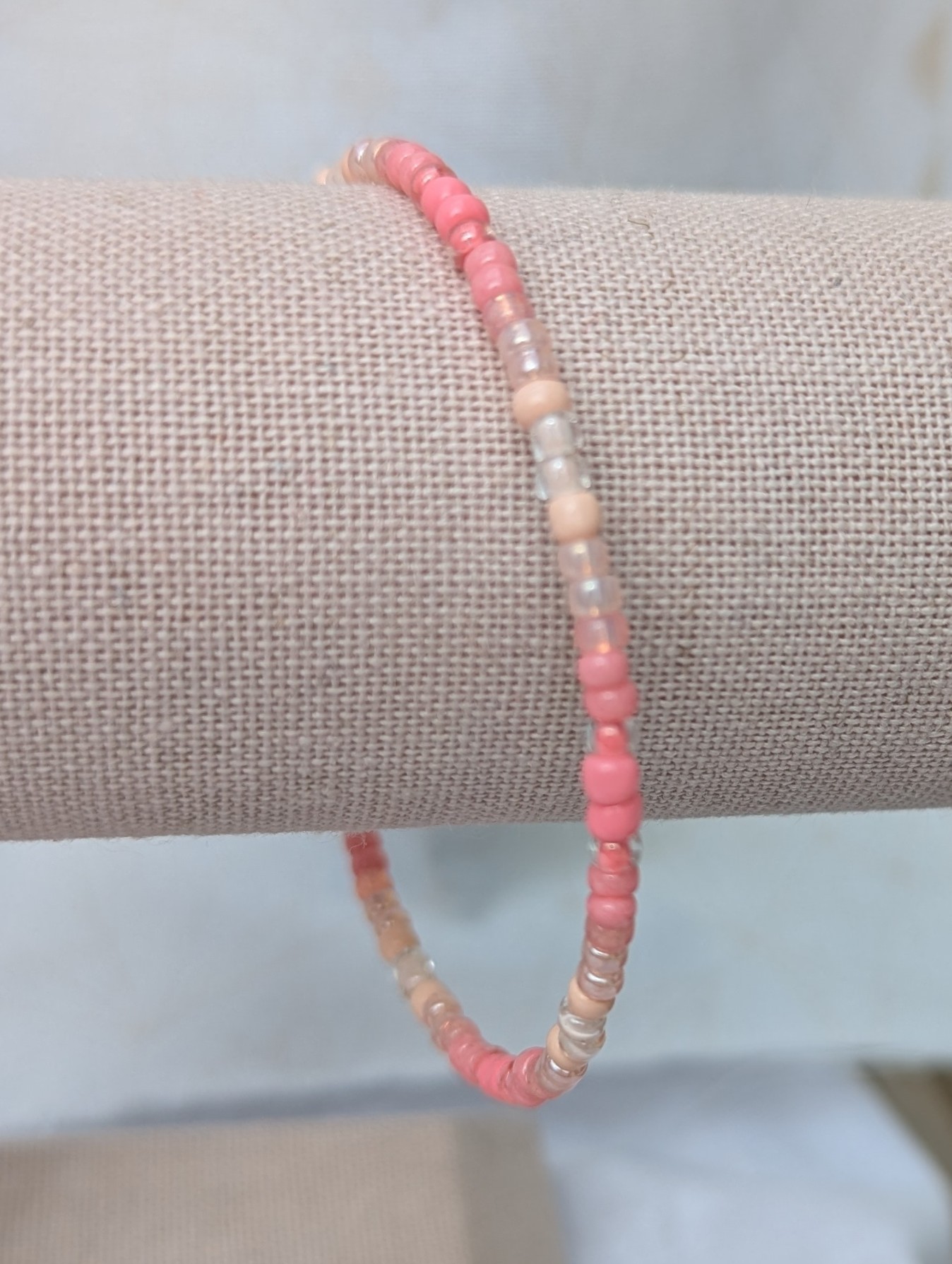 pink gradient bracelet with rose-gold memory wire and pale blush glass seed beads in mixed textures