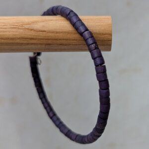 Steel-toned memory wire bracelet with deep midnight indigo wooden cylindrical beads in a clasp-free wrap design.