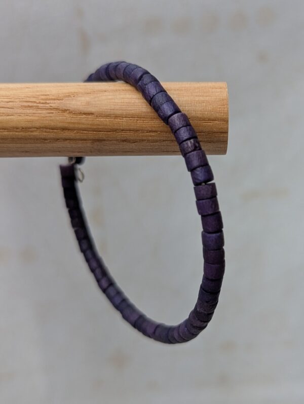 Steel-toned memory wire bracelet with deep midnight indigo wooden cylindrical beads in a clasp-free wrap design.