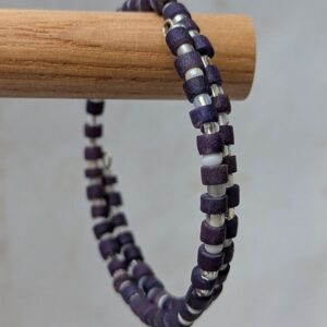 Multi-wrap steel-toned memory wire bracelet with deep indigo wooden beads and frosted white and iridescent clear accent beads in a clasp-free spiral design.