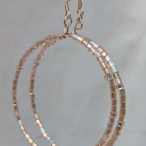 Handmade rose gold hoop earrings with pale pink silver-lined beads in hexagonal and round shapes on rose-gold-colored French hooks.