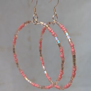 Handmade pale pink beaded hoop earrings with iridescent silver-lined beads on rose-gold-colored memory wire and matching French hooks.