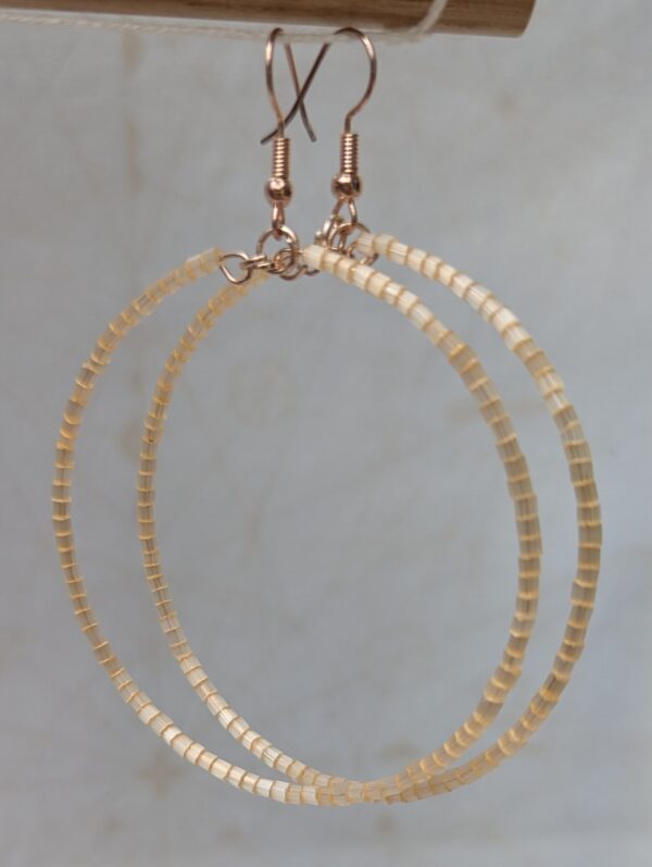 Handmade ivory beaded hoop earrings on rose-gold-colored memory wire with matching rose-gold French hooks.