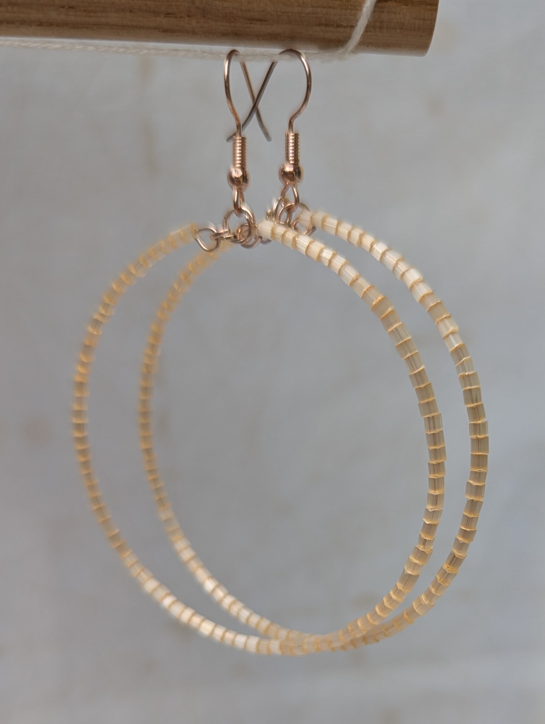 Handmade ivory beaded hoop earrings on rose-gold-colored memory wire with matching rose-gold French hooks.