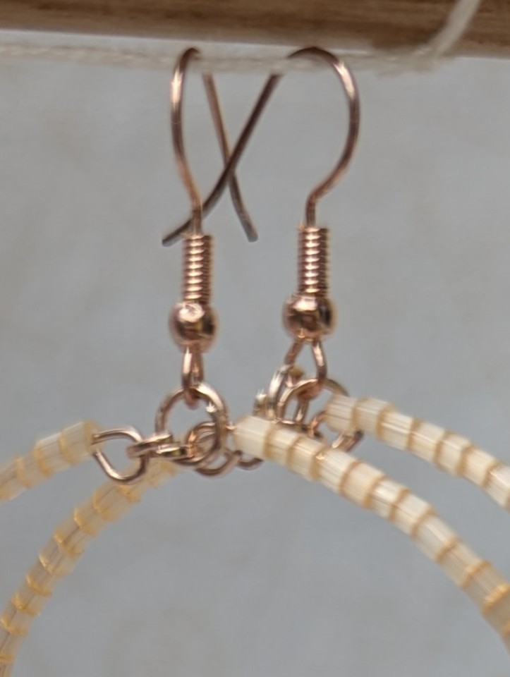Handmade ivory beaded hoop earrings on rose-gold-colored memory wire with matching rose-gold French hooks.