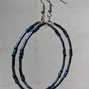 Handmade blue-black metallic hoop earrings with iridescent glass beads on steel-colored memory wire and tungsten-colored French hooks.