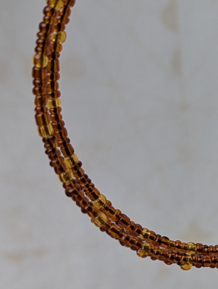Handmade bronze memory wire hoop earrings with chestnut brown and honey amber glass seed beads and bronze French hooks.