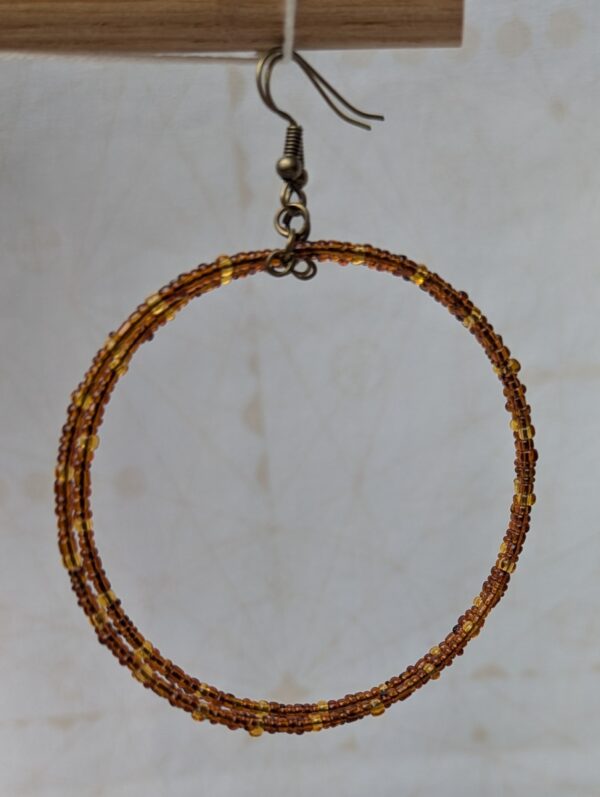 Handmade bronze memory wire hoop earrings with chestnut brown and honey amber glass seed beads and bronze French hooks.
