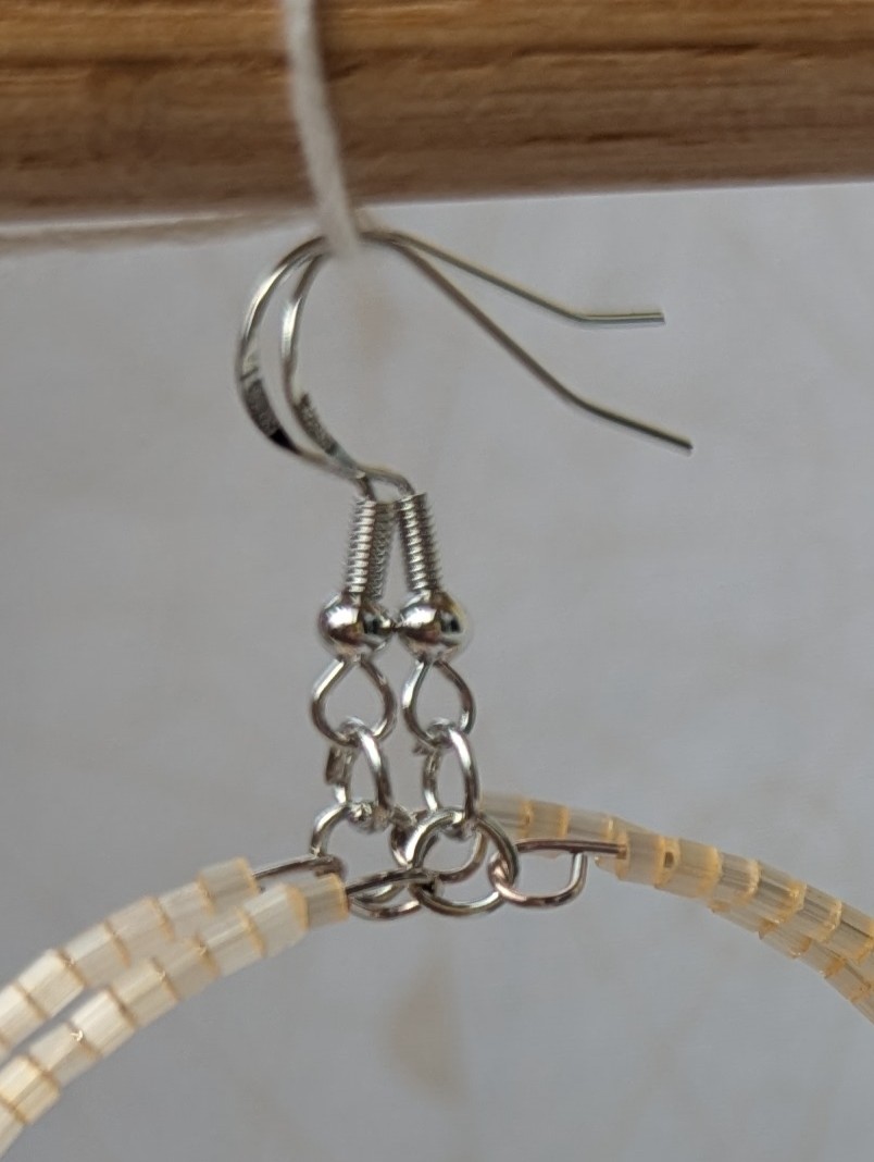 Handmade rose gold hoop earrings with ivory, amber, apricot, coral orange, and tangerine glass beads on memory wire with matching French hooks.