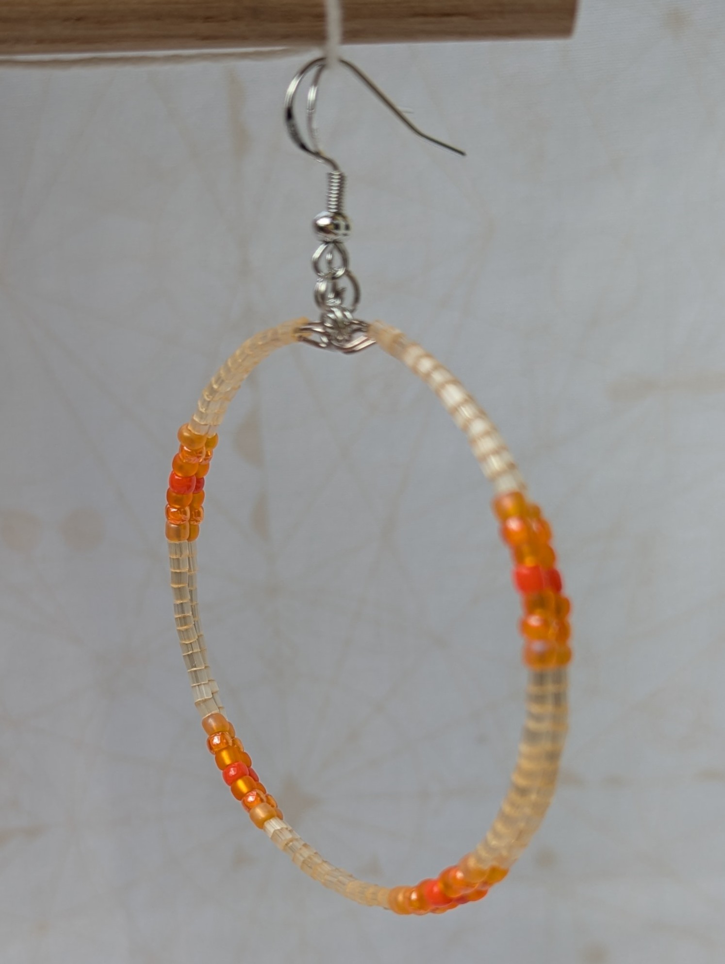 Handmade rose gold hoop earrings with ivory, amber, apricot, coral orange, and tangerine glass beads on memory wire with matching French hooks.