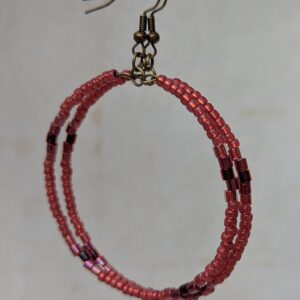 Handmade bronze hoop earrings with scarlet, garnet, raspberry, and wine-red glass beads in mixed shapes and textures on memory wire.