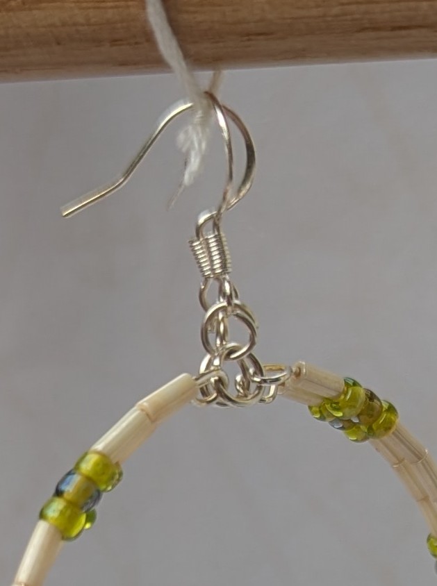 Handmade silver memory wire hoop earrings with creamy ivory tube beads and lime, moss, and chartreuse green glass bead accents on sterling silver hooks.