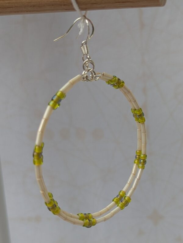 Handmade silver memory wire hoop earrings with creamy ivory tube beads and lime, moss, and chartreuse green glass bead accents on sterling silver hooks.