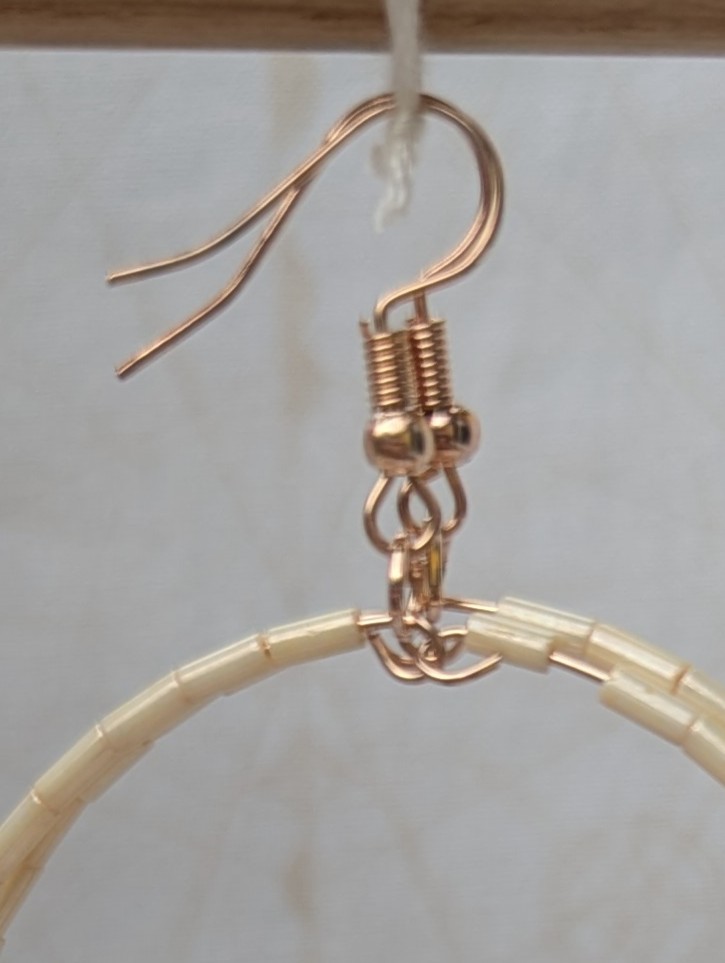 Handmade rose gold hoop earrings with ivory tube beads and lavender, mauve, plum, and orchid purple glass bead accents on rose gold French hooks.