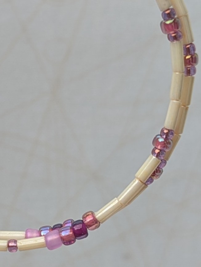 Handmade rose gold hoop earrings with ivory tube beads and lavender, mauve, plum, and orchid purple glass bead accents on rose gold French hooks.