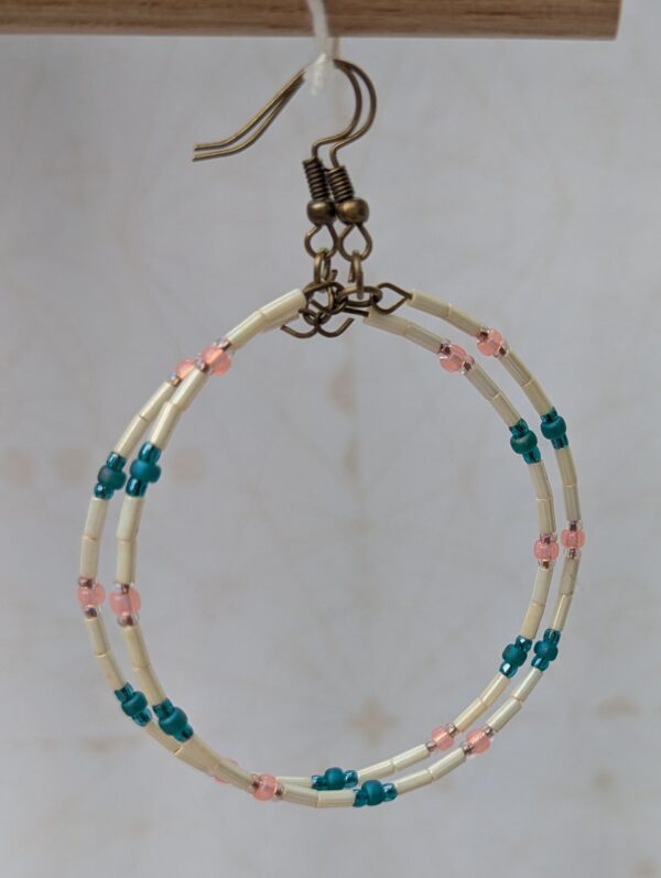 Handmade ivory hoop earrings with blush pink and teal glass bead accents on bronze memory wire and bronze French hooks.